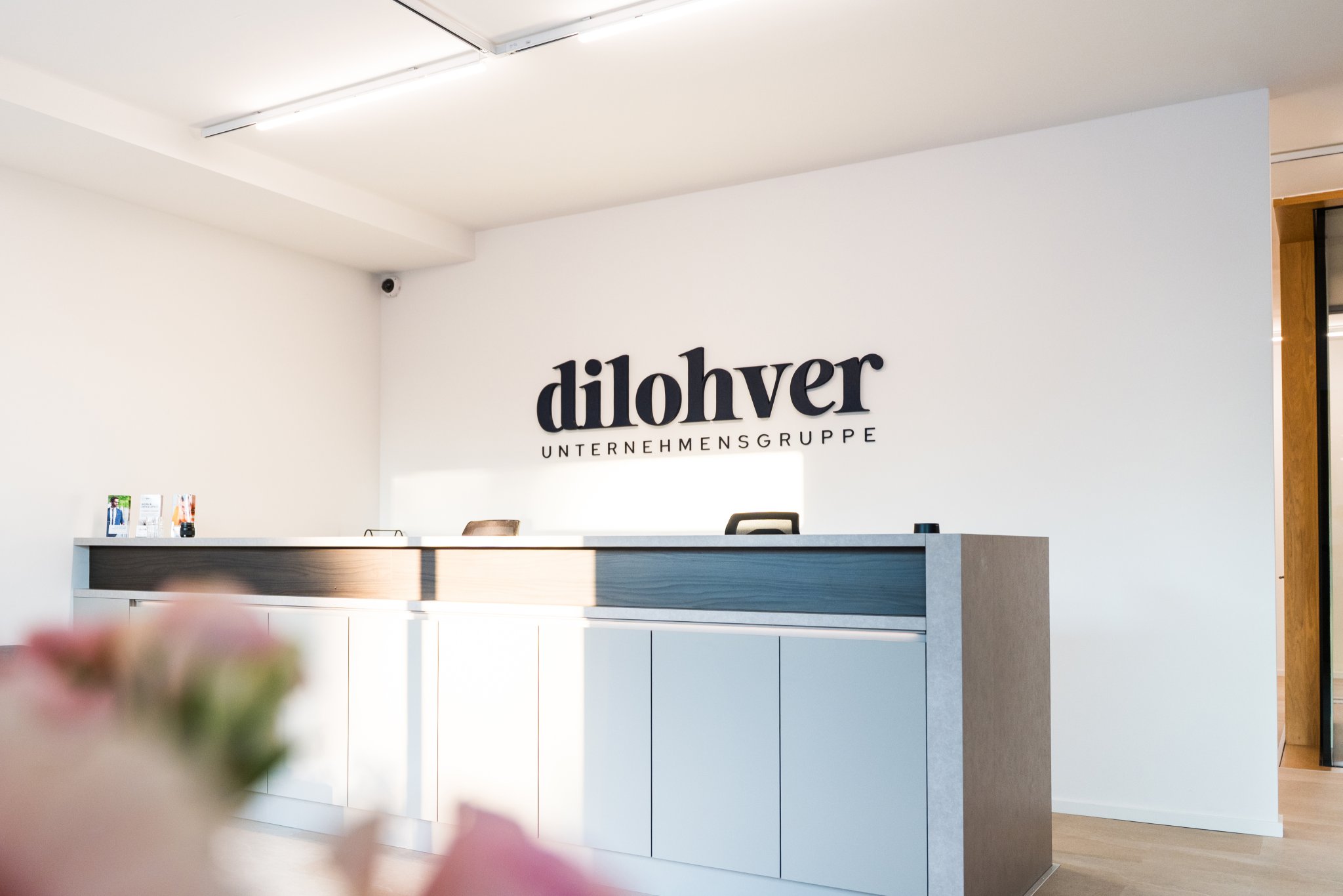 Empfangsbereich der Kanzlei mit Logo an der Wand